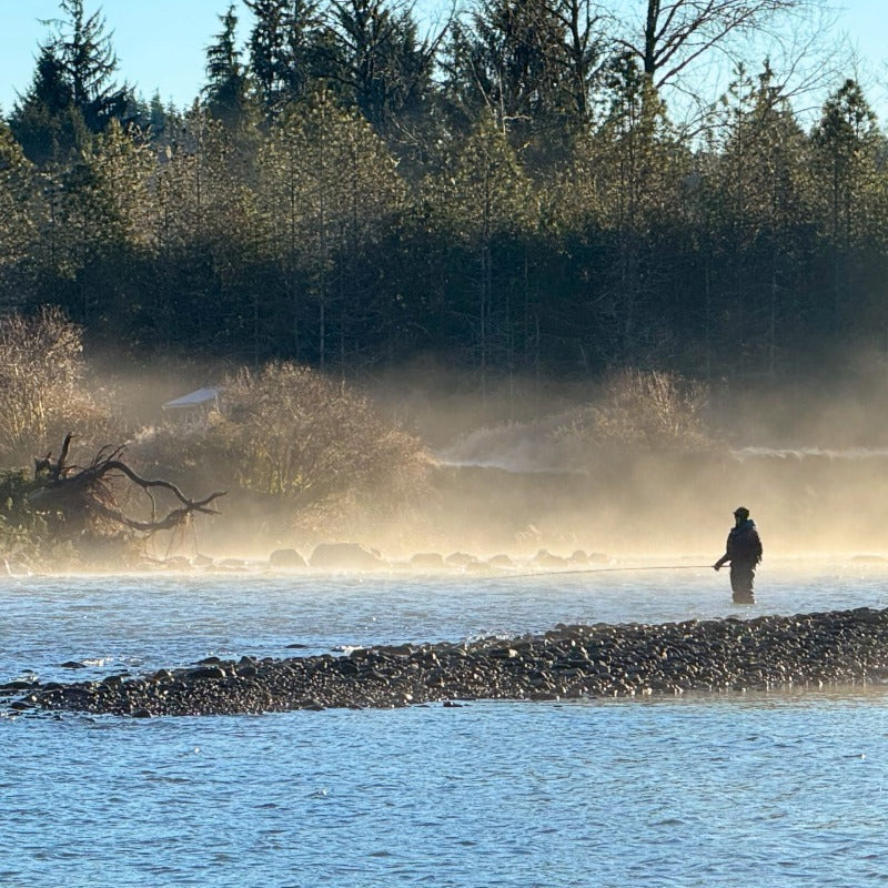 Man fly fishing on a river in the mist