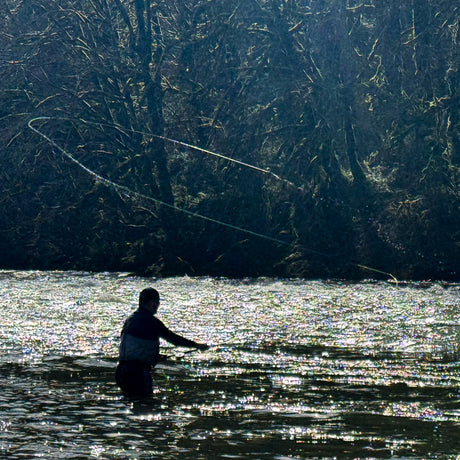 Silhouette of a man casting a spey rod