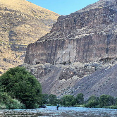 Man casting a fly rod in a deep canyon